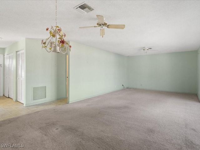 unfurnished room featuring light carpet, a textured ceiling, and ceiling fan