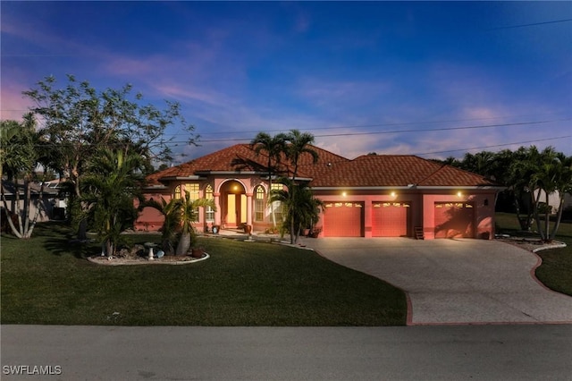 mediterranean / spanish-style home featuring a garage and a lawn