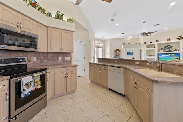 kitchen featuring sink, ceiling fan, decorative backsplash, light tile patterned floors, and appliances with stainless steel finishes