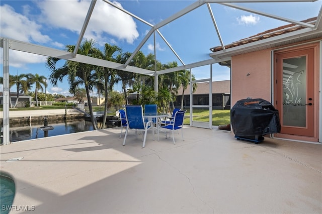 view of patio / terrace featuring a lanai, a grill, and a water view