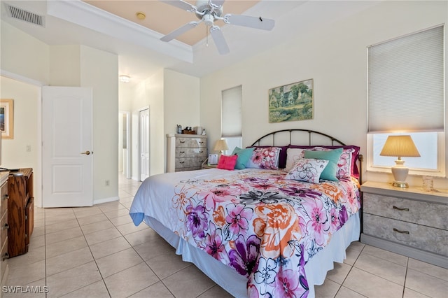 bedroom with ceiling fan, a raised ceiling, and light tile patterned floors