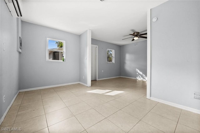 empty room featuring ceiling fan, an AC wall unit, and light tile patterned floors