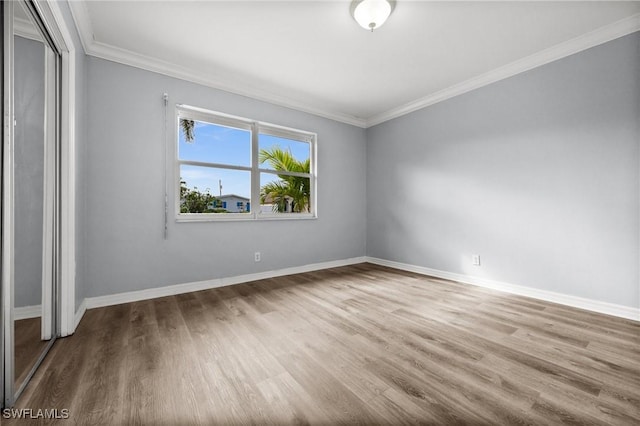 spare room with wood-type flooring and crown molding