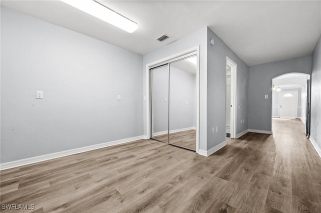 unfurnished bedroom featuring hardwood / wood-style floors and a closet