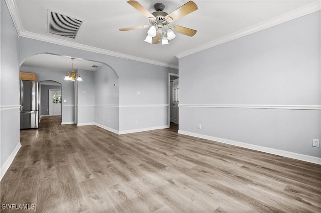 empty room with crown molding, wood-type flooring, and ceiling fan with notable chandelier