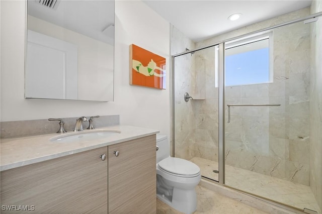 bathroom featuring a shower with door, vanity, and toilet