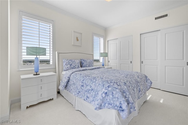 carpeted bedroom with multiple closets and ornamental molding