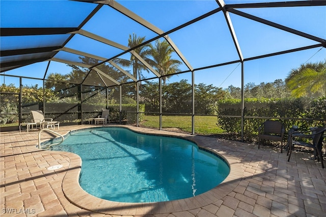 view of swimming pool with glass enclosure and a patio