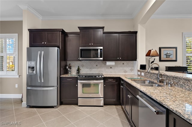 kitchen featuring appliances with stainless steel finishes, tasteful backsplash, light tile patterned floors, and sink