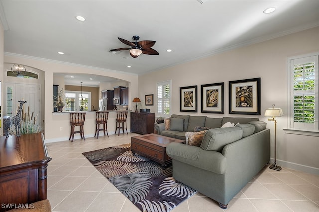 tiled living room featuring crown molding, ceiling fan, and a healthy amount of sunlight