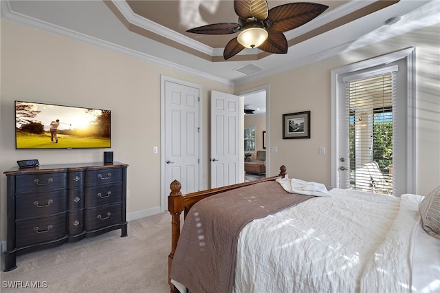 carpeted bedroom featuring access to outside, ceiling fan, a tray ceiling, and ornamental molding