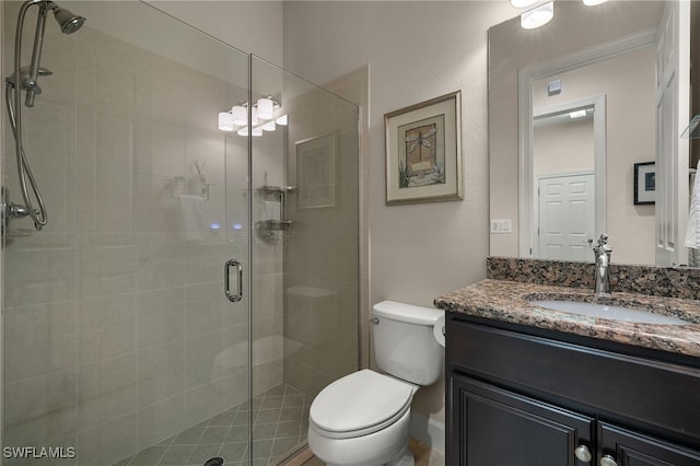 bathroom with vanity, an enclosed shower, and toilet