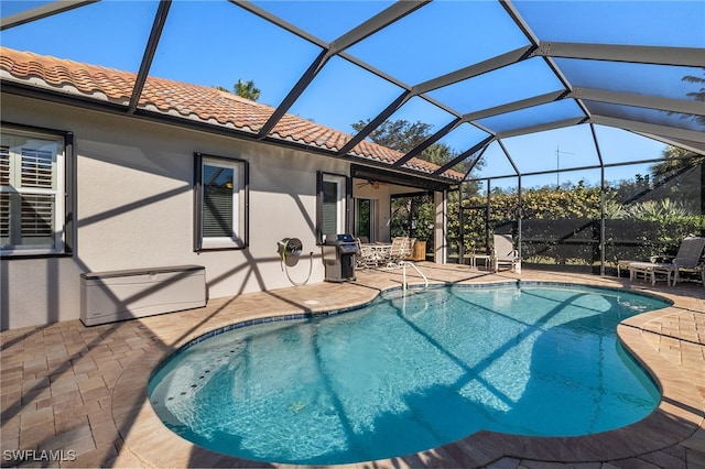 view of swimming pool with glass enclosure, a grill, ceiling fan, and a patio