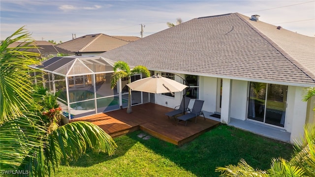 rear view of property with a lawn, glass enclosure, and a pool side deck