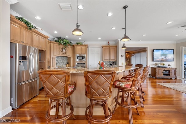 kitchen with backsplash, hanging light fixtures, light stone countertops, ornamental molding, and appliances with stainless steel finishes