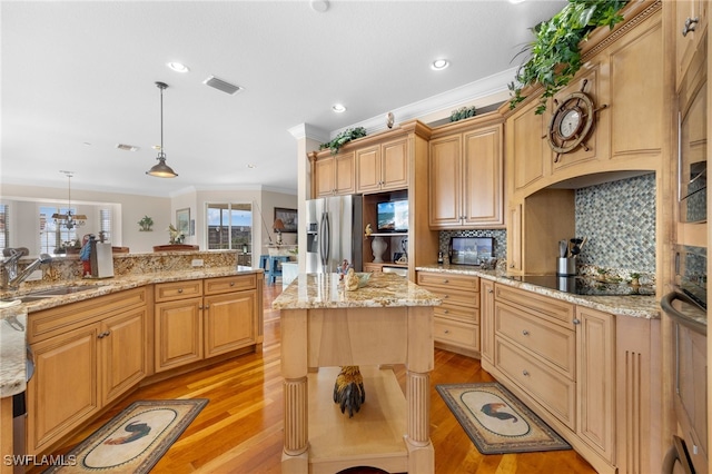 kitchen with a center island, hanging light fixtures, light wood-type flooring, black electric cooktop, and tasteful backsplash