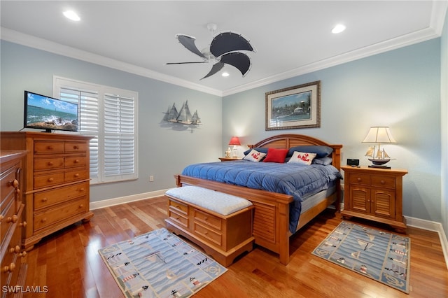 bedroom featuring ceiling fan, crown molding, and light hardwood / wood-style flooring