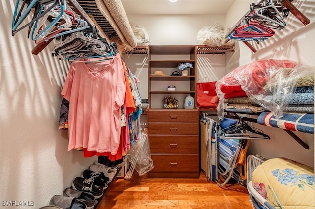 walk in closet with light hardwood / wood-style floors