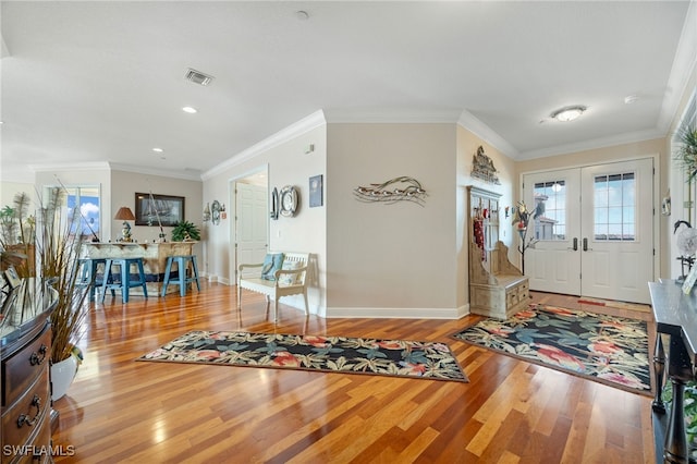 entryway with wood-type flooring, french doors, and crown molding