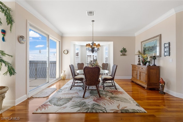 dining space featuring a chandelier, wood-type flooring, and ornamental molding