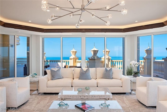 sunroom with a water view, an inviting chandelier, and a wealth of natural light