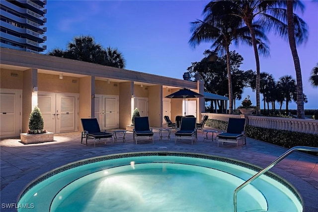 pool at dusk with a patio