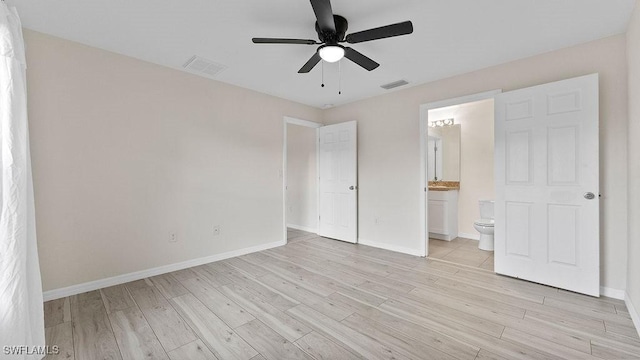 unfurnished bedroom featuring ensuite bathroom, ceiling fan, and light wood-type flooring