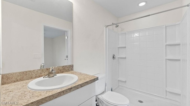 bathroom with a shower, vanity, and toilet