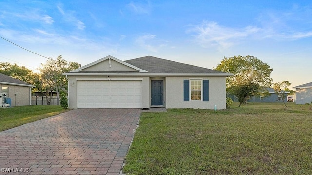 ranch-style home featuring a garage and a yard