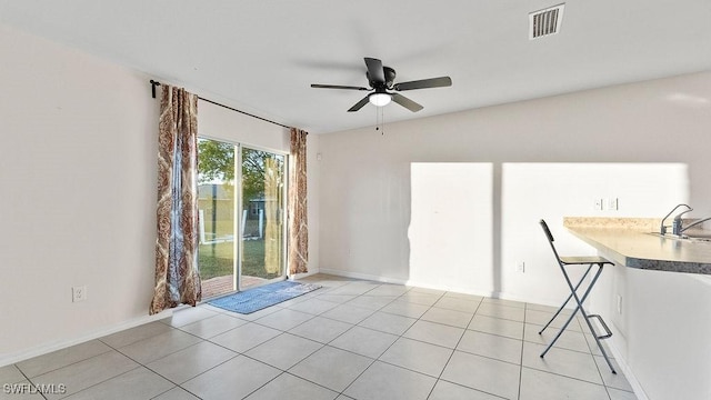 tiled spare room featuring ceiling fan and sink