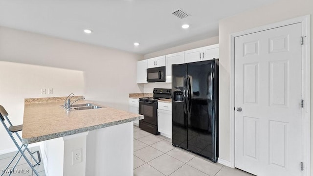 kitchen featuring kitchen peninsula, a kitchen breakfast bar, black appliances, white cabinets, and light tile patterned flooring