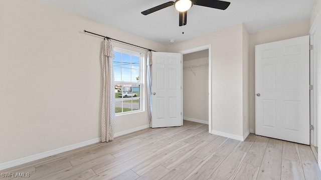 unfurnished bedroom with ceiling fan, a closet, and light hardwood / wood-style flooring