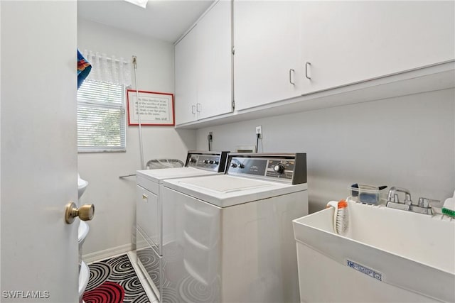 laundry room with washer and clothes dryer, cabinets, sink, and tile patterned floors