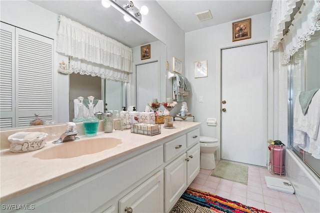 full bathroom featuring tile patterned flooring, vanity, toilet, and combined bath / shower with glass door