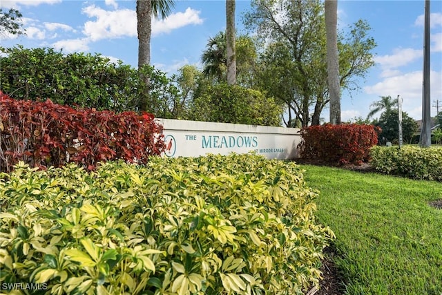 community sign featuring a yard