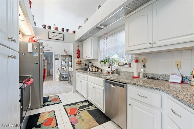 kitchen with tasteful backsplash, white cabinetry, light tile patterned floors, and stainless steel appliances