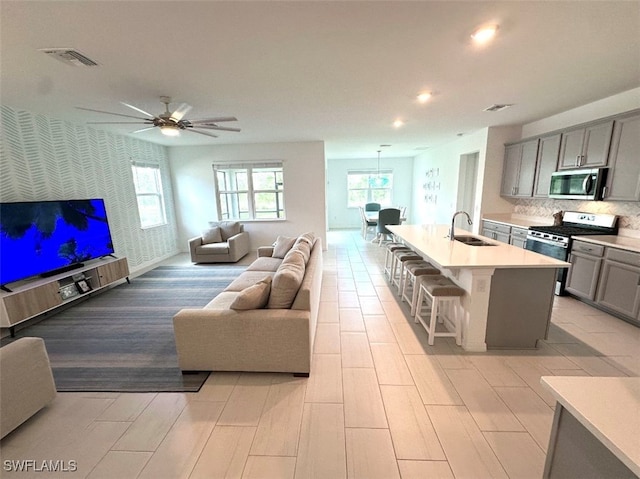 living room featuring ceiling fan and sink