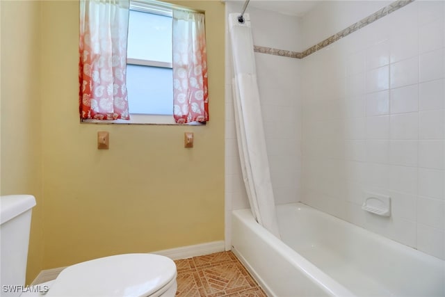 bathroom featuring tile patterned flooring, shower / tub combo, and toilet