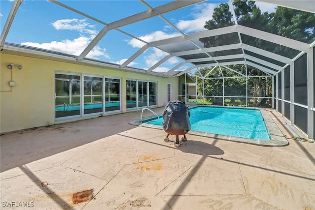 view of pool with glass enclosure and a patio area