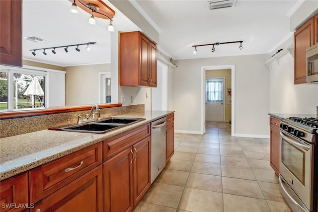 kitchen featuring sink, light stone countertops, light tile patterned floors, a wealth of natural light, and stainless steel appliances