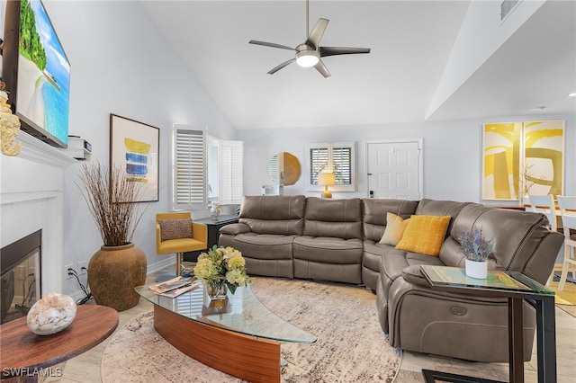 living room with ceiling fan and high vaulted ceiling