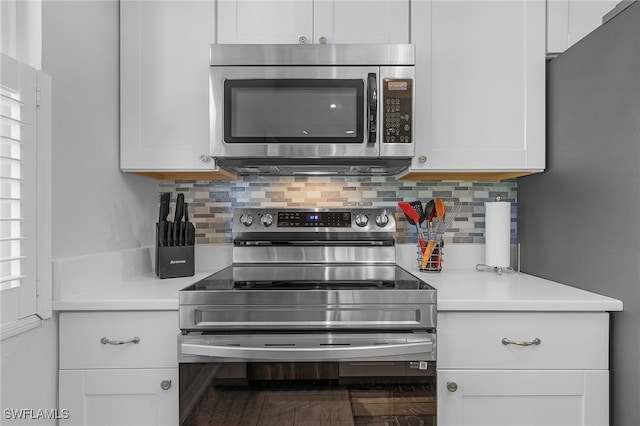 kitchen with tasteful backsplash, white cabinets, and stainless steel appliances