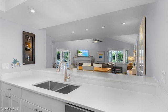 kitchen featuring white cabinets, ceiling fan, sink, and vaulted ceiling