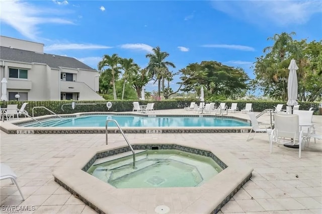 view of swimming pool with a patio area and a community hot tub