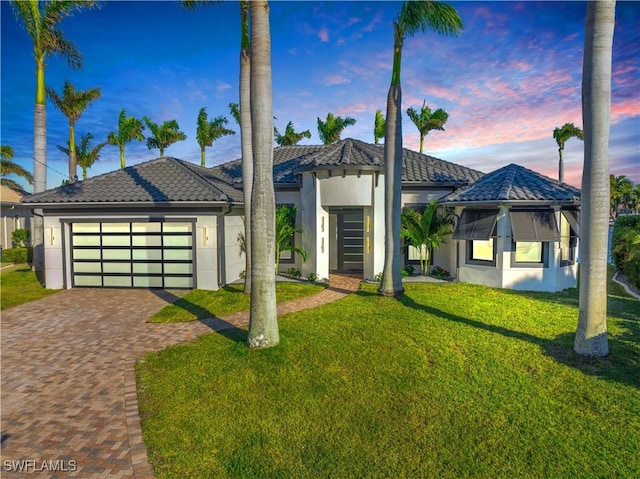 view of front of property featuring a garage and a lawn