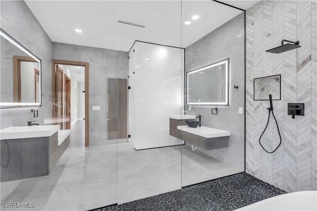 bathroom with vanity, tile walls, and a tile shower