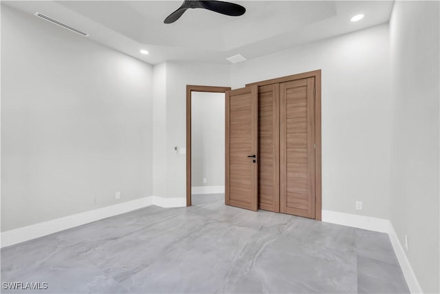 unfurnished bedroom with ceiling fan and a closet