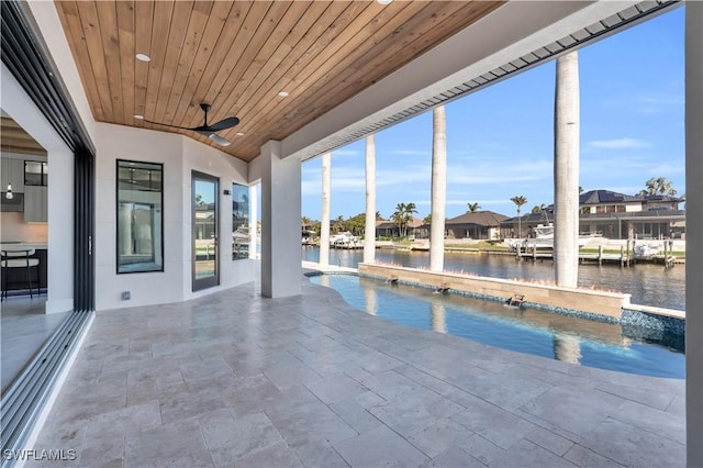 view of pool with a patio area, ceiling fan, and a water view