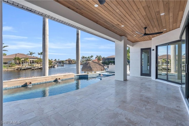 view of swimming pool with a jacuzzi, a patio area, pool water feature, and a water view