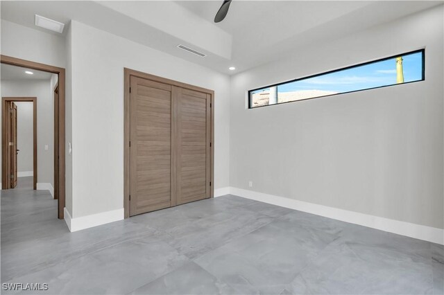 unfurnished bedroom with ceiling fan and a closet